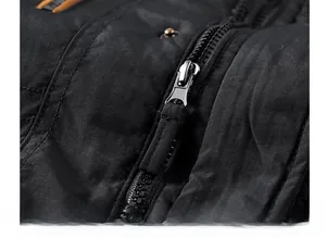 Detailed macro shot of the black jacket's durable metal zipper and fabric puller
