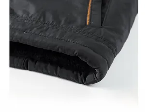 Close-up of winter jacket hem showing thick black fleece lining and durable stitching