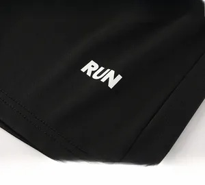 Dettaglio di pantaloncini neri in mesh con stampa bianca RUN per abbigliamento sportivo