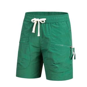 Detail of forest green summer shorts featuring an elastic waistband and zippered pockets