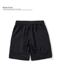 Rear view of black quick-dry athletic shorts with an elastic waistband on white backdrop