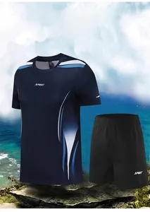 Ensemble de sport pour homme avec t-shirt bleu et short noir sur une plage rocheuse