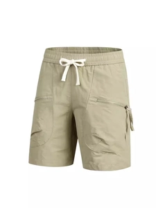 Detail of olive green quick-dry shorts featuring elastic waist and zipper pockets