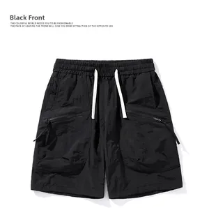 Detail of black ice silk shorts showing elastic waist with white drawstring and zipper pocket