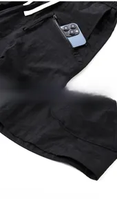 Detail of cargo shorts showing tactical multi-pocket design and smooth nylon fabric texture