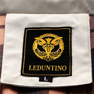 Detailed macro view of the inner neck label and fleece plaid lining of the men's jacket