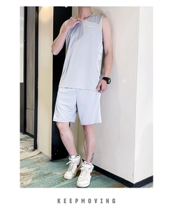 Détail du tissu en maille respirante gris clair sur le gilet de sport et le short homme