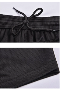 Detail of black breathable mesh soccer shorts showing elastic drawstring waistband and seams