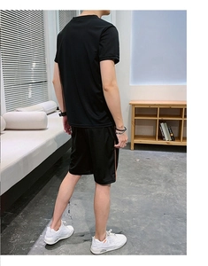 Vue arrière du t-shirt de sport et short noir pour homme avec rayures orange latérales