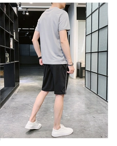 Vue arrière du t-shirt gris ample pour hommes et short de sport noir avec rayures blanches