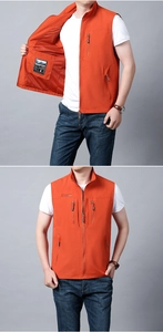 Detail view of orange outdoor vest showing multi-pocket design and breathable mesh lining