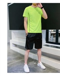 Détail du t-shirt de sport vert néon et du short noir sur modèle pour le fitness d'été