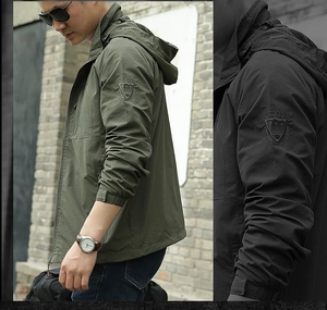 Detail view of men's outdoor jacket showing sleeve embroidery and windproof hooded design