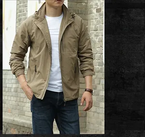 Detail of tan hooded outdoor jacket with windproof fabric and zip closure for men