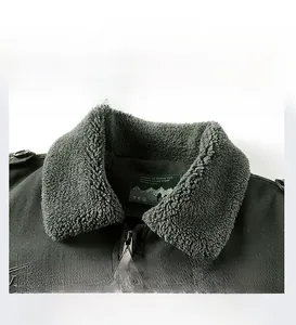Detail of dark green jacket with grey faux shearling collar and metallic zipper