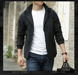 Detail showing high-quality zipper pocket on black hooded windbreaker for men