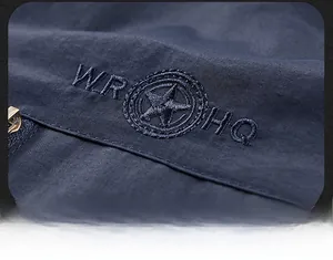 Macro detail of high-quality embroidery badge and navy blue fabric on a casual vest