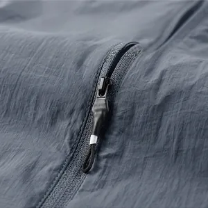 Detailed macro view of the black metal zipper on durable blue-grey outdoor fabric