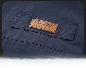 Macro shot of the brown leather label with classic 1902 embossing on dark blue vest
