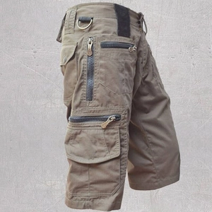 Close-up of tactical cargo shorts with multiple zipper pockets and a metal D-ring detail