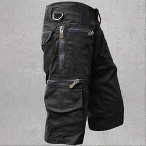 Detail of tactical cargo shorts featuring multiple zipper pockets and a metal D-ring attachment
