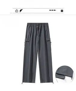 Detail of dark grey parachute pants featuring adjustable toggle hem and side cargo pockets