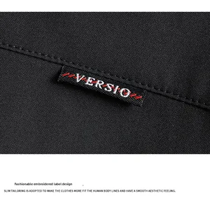 Detail of high-density black twill fabric with embroidered logo patch and fine stitching