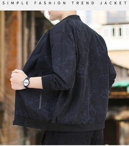 Detail view of men's black jacket with marble pattern and ribbed cuffs on street background