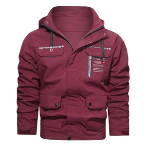 Detail view of men's burgundy hooded jacket with front pockets and white text slogan