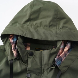 Close-up of military green jacket collar featuring classic plaid lining and adjustable hood