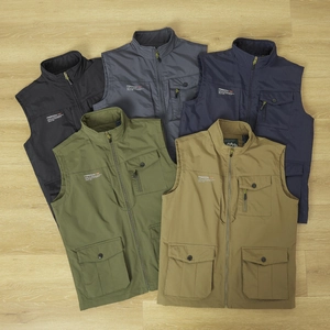 Flat lay of men's multi-pocket fishing vests in five colors on light wood background