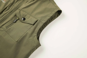 Detail of olive green fishing vest with durable cargo pockets and secure metal snaps