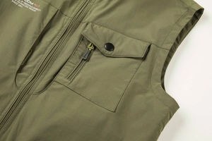 Detail of army green utility vest showing metal zipper, snap pocket and printed text