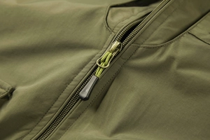 Close-up of olive green fishing vest metal zipper with textured woven drawstring detail