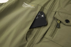Detail view of multi-pocket army green fishing vest showing phone storage capacity