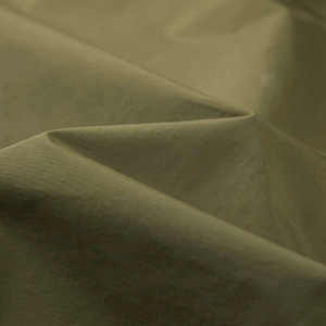 Detailed macro view of olive green twill fabric texture for outdoor functional vest