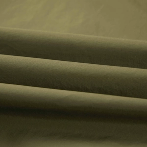 Close-up of olive green fishing vest showing high-quality twill fabric texture and durable material