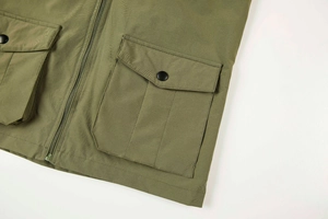 Detail view of military green fishing vest with large utility pockets and metal snaps