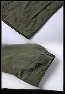 Detail of army green jacket showing zippered pocket and adjustable velcro cuffs