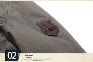 Detail of grey-green jacket shoulder featuring fashion leather patch and twill texture