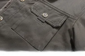 Macro detail of twill cotton jacket featuring a flap pocket and vintage metal button