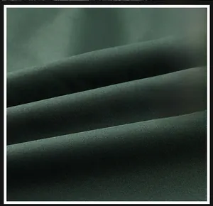 Detailed macro view of dark green twill fabric texture for outdoor utility vests