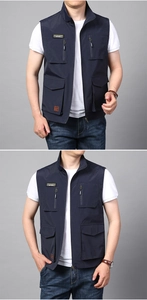 Close-up detail of a dark blue outdoor fishing vest with multiple functional pockets and zipper