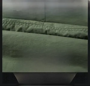 Detail of warm military green jacket fabric with durable double stitching for winter wear