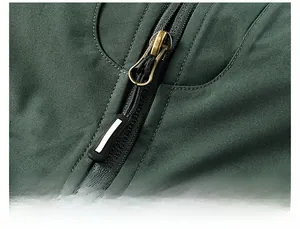 Detail of outdoor vest featuring metal zipper with reflective puller on green fabric