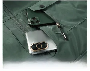 Close-up of deep chest pockets on olive green outdoor vest showing storage capacity