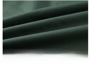 Macro shot of dark green outdoor vest fabric showing high-quality textile texture