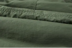 Close-up of olive green washed cotton fabric with durable double-stitch detailing