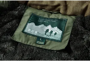 Detail of military green jacket collar featuring thick fleece lining and outdoor mountain label