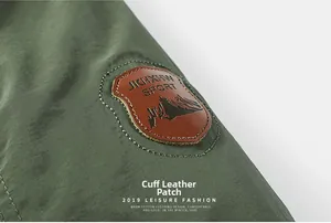 Detail shot of a round brown leather patch on the sleeve of a green winter jacket